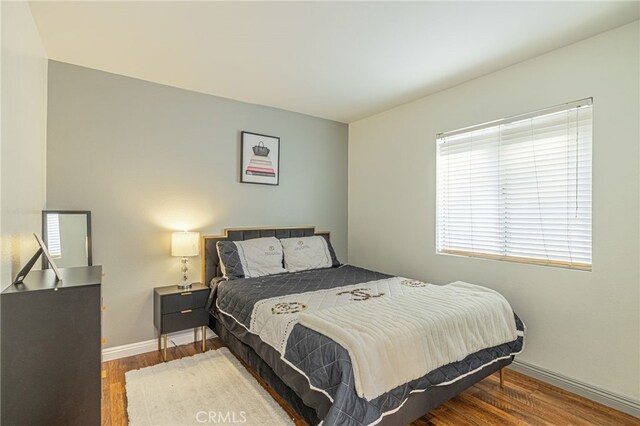 bedroom with dark hardwood / wood-style flooring