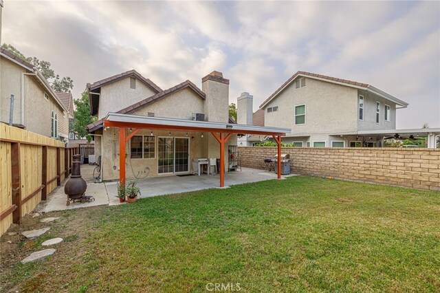 back of property with a patio and a yard