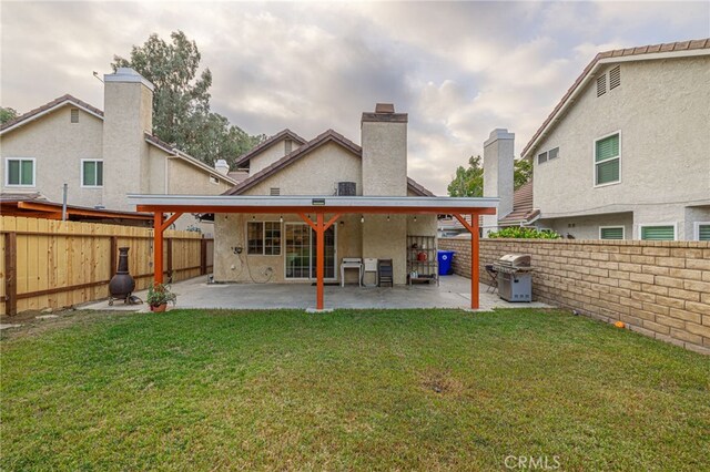 back of house featuring a patio and a yard