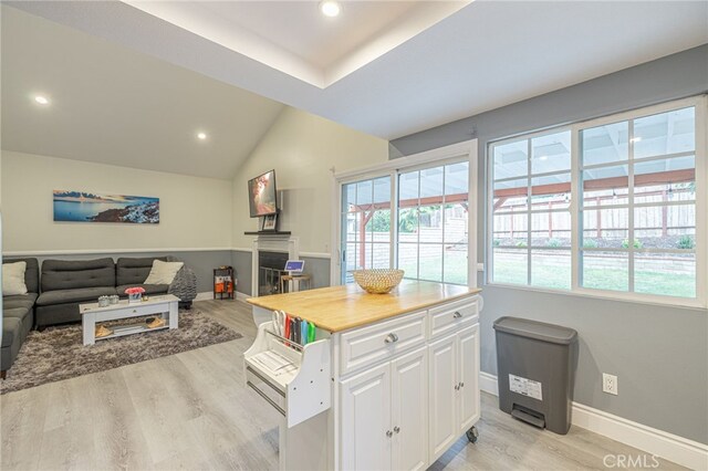 kitchen featuring lofted ceiling, white cabinets, and light wood-type flooring