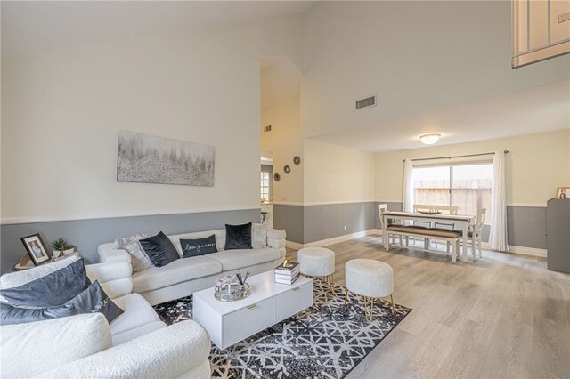 living room with hardwood / wood-style flooring and high vaulted ceiling