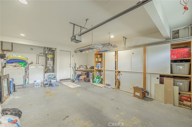 garage featuring water heater, washing machine and dryer, and a garage door opener