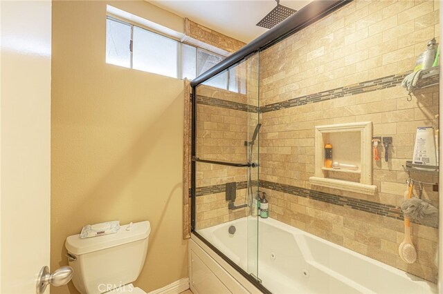 bathroom featuring shower / bath combination with glass door and toilet