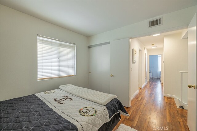 bedroom featuring dark wood-type flooring and a closet