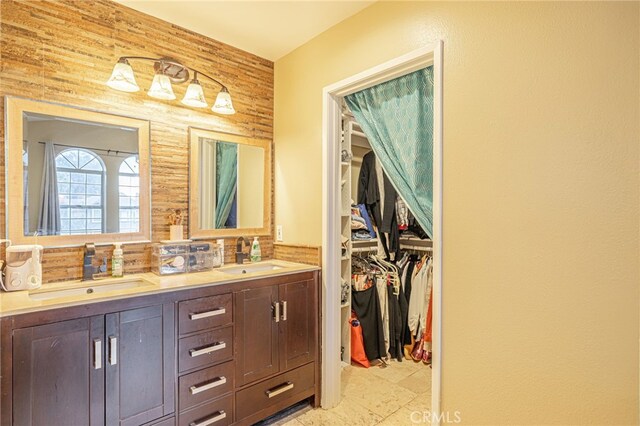 bathroom with vanity, decorative backsplash, wood walls, and tile patterned floors