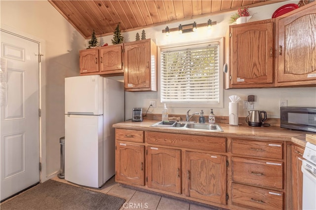 kitchen featuring light tile patterned flooring, sink, wooden ceiling, and white refrigerator