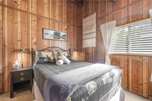 bedroom featuring wooden walls and light carpet