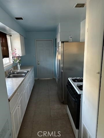 4772 Cebrian, New Cuyama, CA 93254 - kitchen with gas stove, white cabinets, light countertops, and light tile patterned floors