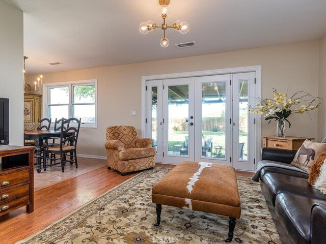 living room with a chandelier, light hardwood / wood-style flooring, and plenty of natural light