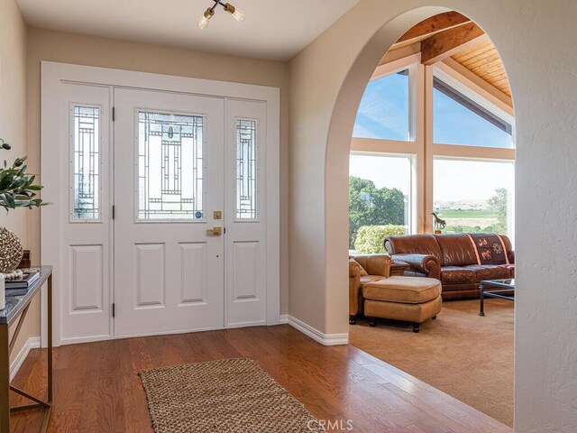 entrance foyer featuring lofted ceiling with beams and hardwood / wood-style flooring