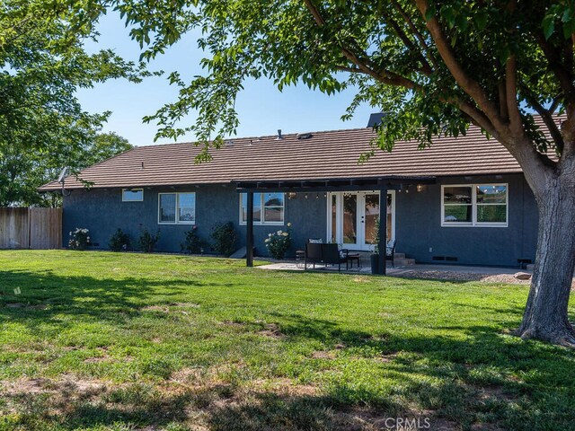 back of property with a patio and a lawn