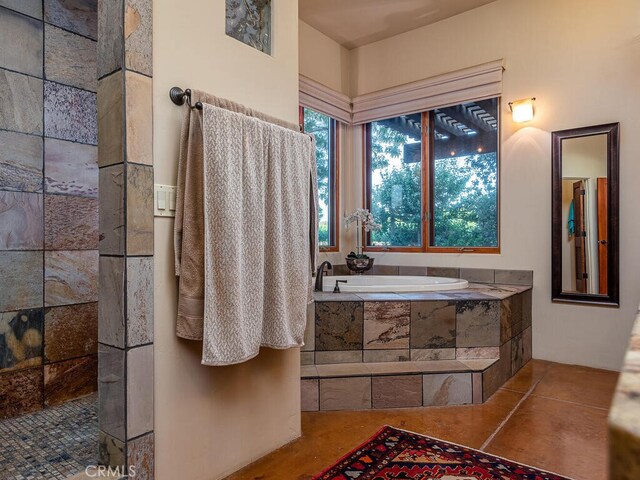 bathroom featuring tile patterned flooring and tiled tub