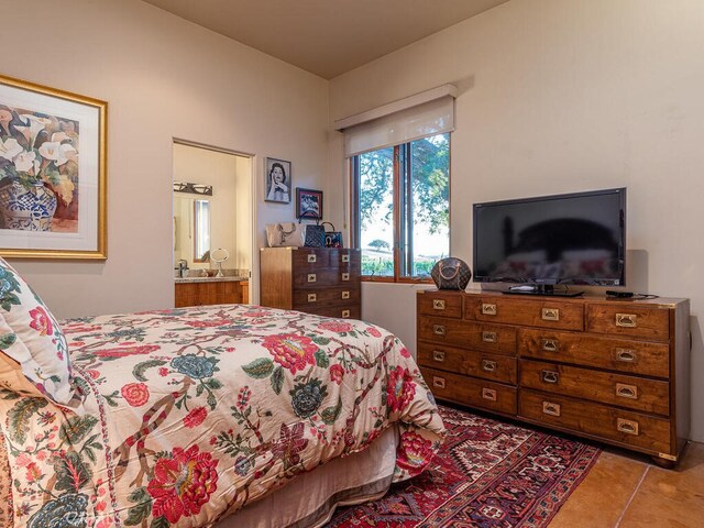 bedroom featuring ensuite bath and light tile patterned floors