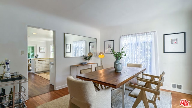 dining space with a wealth of natural light and dark hardwood / wood-style floors