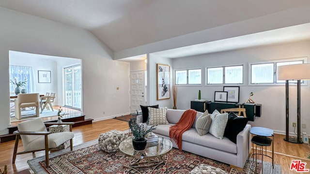 living room featuring light hardwood / wood-style flooring, a healthy amount of sunlight, and lofted ceiling