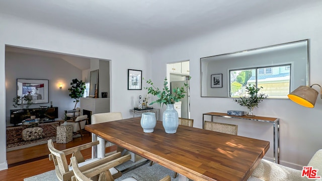 dining space featuring lofted ceiling and hardwood / wood-style flooring