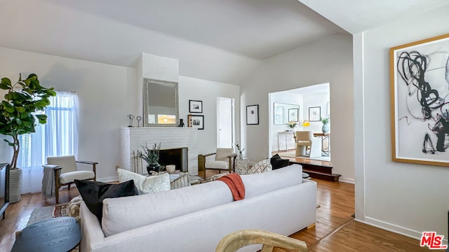 living room featuring lofted ceiling and hardwood / wood-style flooring