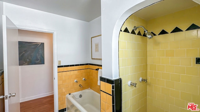 bathroom with tiled shower / bath and hardwood / wood-style flooring