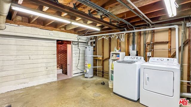 basement featuring washing machine and clothes dryer and strapped water heater