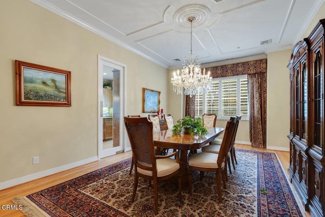 dining space featuring a notable chandelier, hardwood / wood-style floors, and crown molding