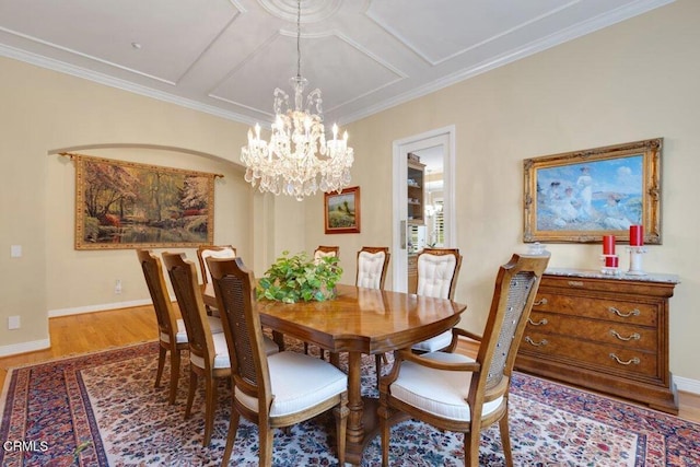 dining area with coffered ceiling, crown molding, a chandelier, and wood-type flooring