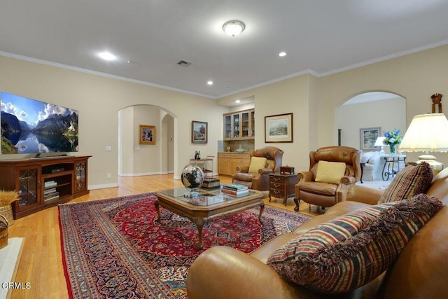 living room featuring ornamental molding and light hardwood / wood-style flooring