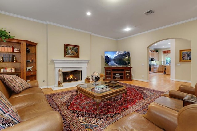 living room featuring light hardwood / wood-style floors and crown molding