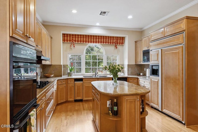 kitchen with sink, decorative backsplash, a center island, and black appliances