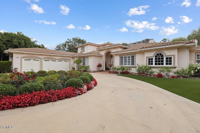 mediterranean / spanish-style home featuring a front yard and a garage