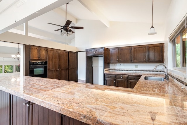 kitchen with beam ceiling, black oven, pendant lighting, and a healthy amount of sunlight