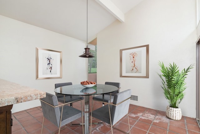 dining room with vaulted ceiling with beams