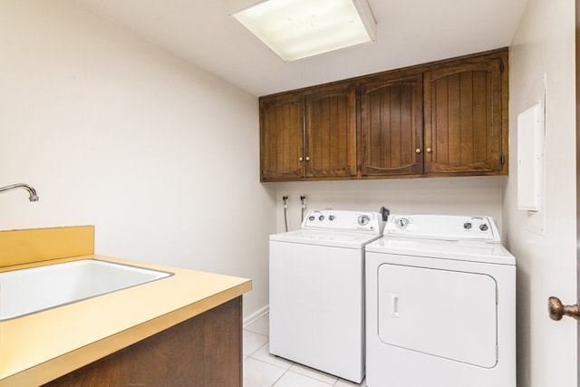 clothes washing area with washing machine and clothes dryer, sink, light tile patterned floors, and cabinets