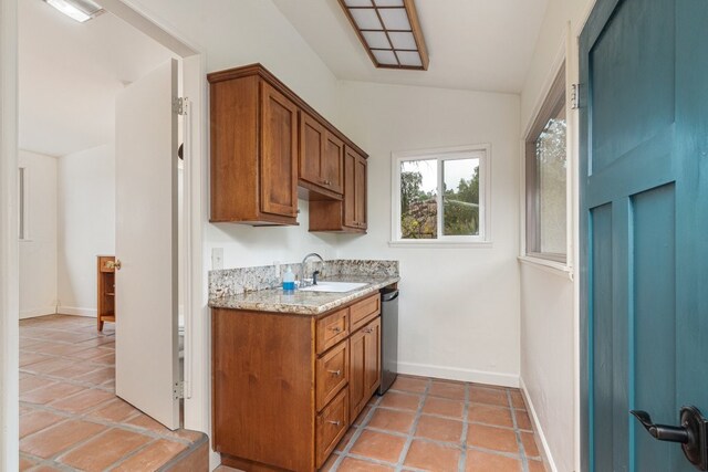 kitchen featuring dishwasher, sink, light stone counters, vaulted ceiling, and light tile patterned floors