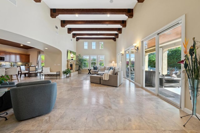 living room with beam ceiling and a high ceiling