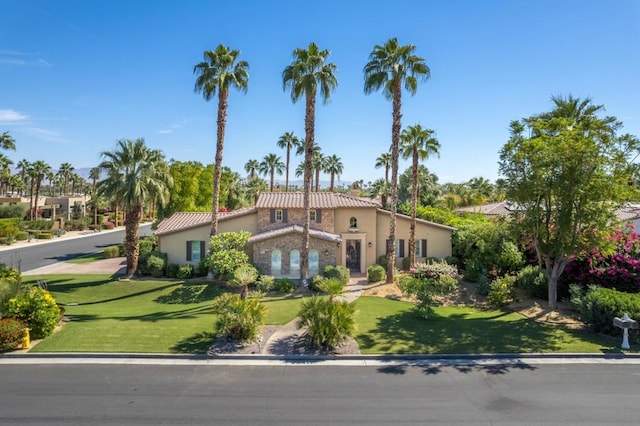 mediterranean / spanish house featuring a front yard