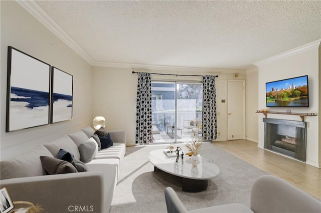 living room with light wood-type flooring, a textured ceiling, and ornamental molding