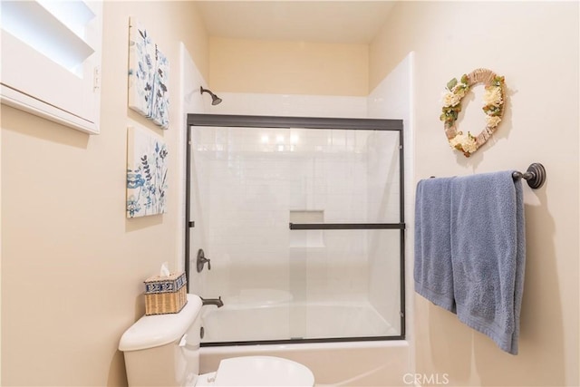 bathroom with shower / bath combination with glass door and toilet