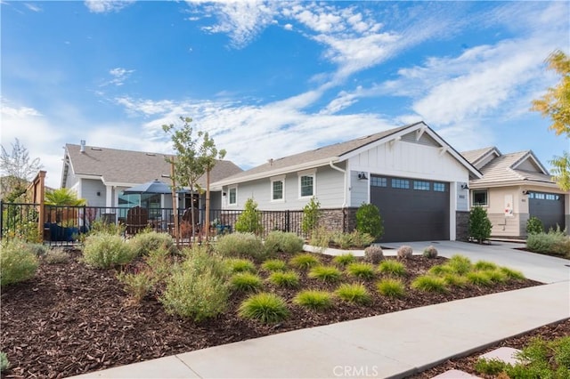 ranch-style home featuring driveway, board and batten siding, an attached garage, and fence