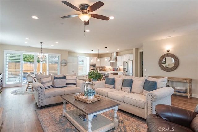 living area with a ceiling fan, recessed lighting, and wood finished floors