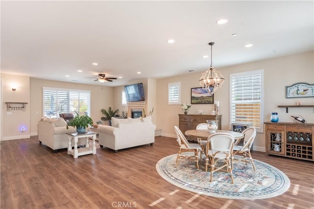 dining area with hardwood / wood-style flooring and ceiling fan with notable chandelier