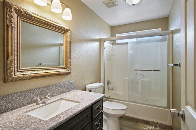 full bathroom featuring bath / shower combo with glass door, vanity, a textured ceiling, hardwood / wood-style flooring, and toilet