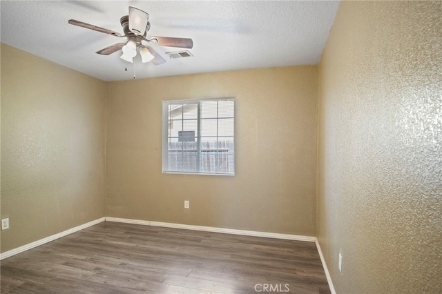 empty room featuring a textured ceiling, ceiling fan, and dark hardwood / wood-style floors