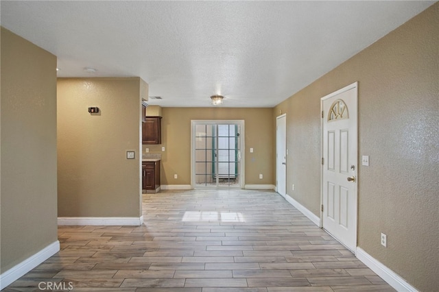 entrance foyer featuring a textured ceiling and light hardwood / wood-style flooring