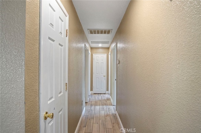 hallway featuring hardwood / wood-style floors and a textured ceiling