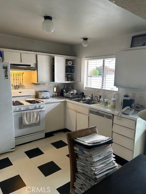 kitchen featuring white cabinets, ventilation hood, white appliances, and sink