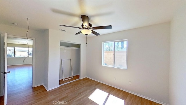 unfurnished bedroom with a closet, hardwood / wood-style flooring, and ceiling fan