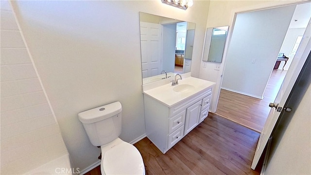 bathroom with toilet, hardwood / wood-style flooring, and vanity