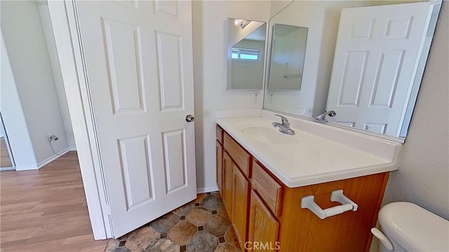 bathroom featuring vanity, hardwood / wood-style flooring, and toilet