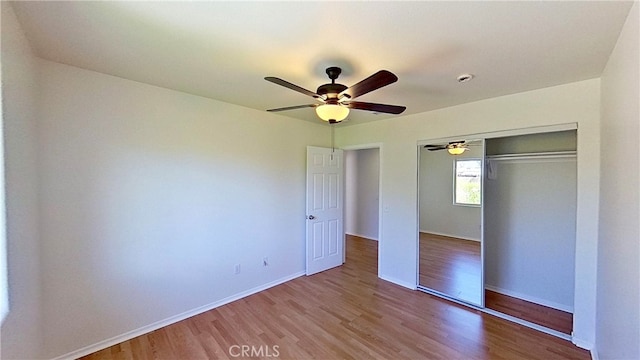 unfurnished bedroom with a closet, wood-type flooring, and ceiling fan