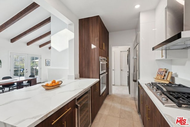 kitchen featuring wine cooler, white cabinetry, light stone countertops, appliances with stainless steel finishes, and wall chimney exhaust hood